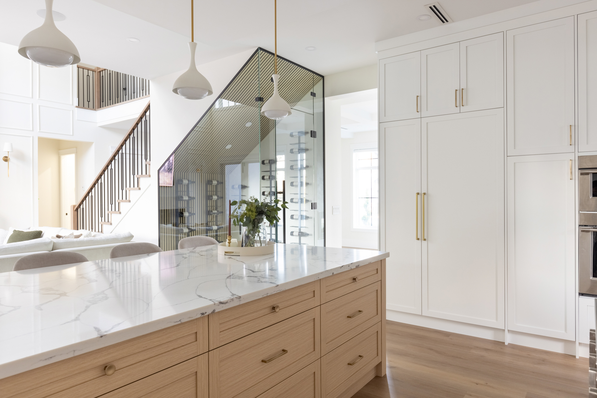 Signature Service project — kitchen island with marble waterfall countertop and under-stair glass wine display